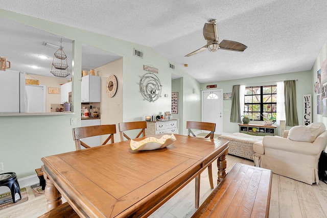 1742 SW Hampshire Ln, Port Saint Lucie, FL 34953 - dining space with a textured ceiling, light wood-style flooring, ceiling fan, and vaulted ceiling