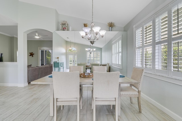 dining space featuring lofted ceiling, light wood-style flooring, plenty of natural light, and ceiling fan with notable chandelier
