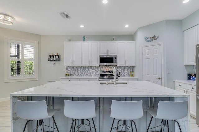kitchen featuring recessed lighting, visible vents, white cabinets, stainless steel appliances, and tasteful backsplash
