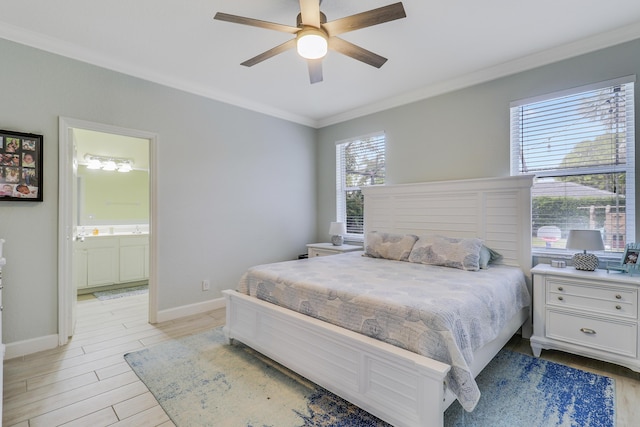 bedroom featuring ensuite bath, crown molding, light wood-style flooring, and baseboards