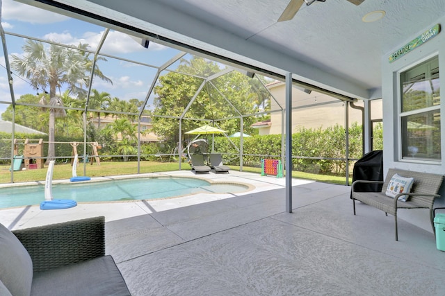 outdoor pool featuring a hot tub, ceiling fan, a lanai, and a patio