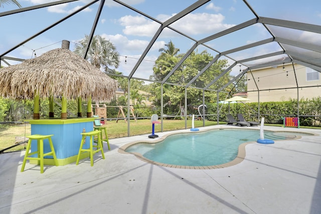 outdoor pool featuring outdoor dry bar, a patio, a lawn, and glass enclosure