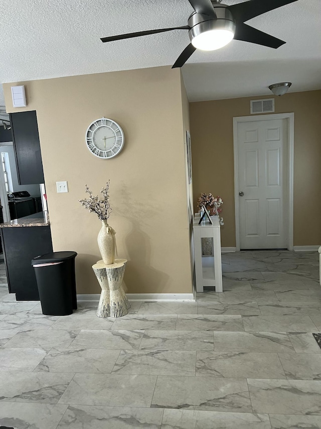 detailed view of a ceiling fan, baseboards, and a textured ceiling
