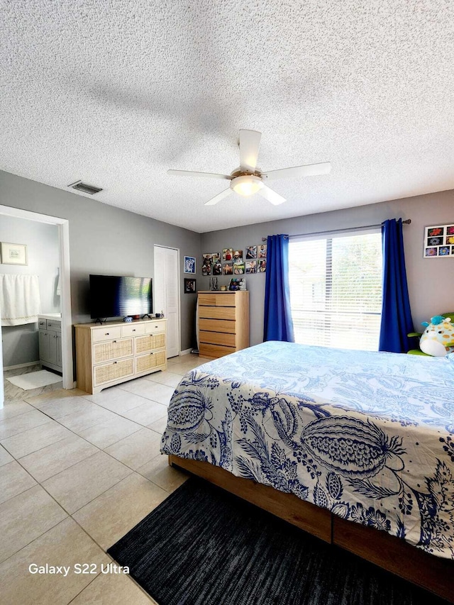 bedroom with tile patterned flooring, a textured ceiling, ceiling fan, and visible vents