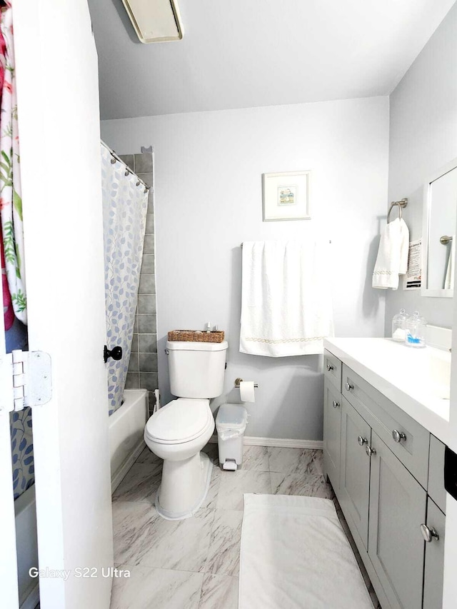 bathroom featuring vanity, toilet, shower / bath combo with shower curtain, and marble finish floor