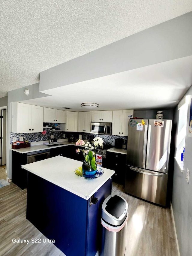 kitchen featuring a sink, a center island, light wood-type flooring, and appliances with stainless steel finishes