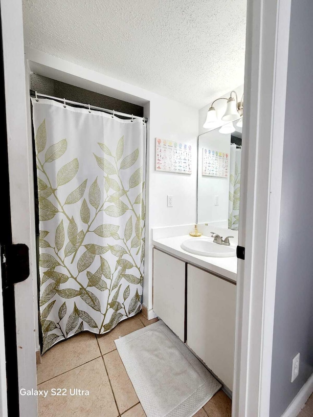 bathroom featuring a textured ceiling, tile patterned flooring, and vanity