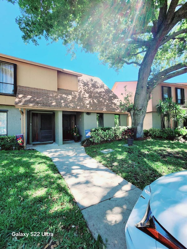 view of front facade with a front yard and stucco siding