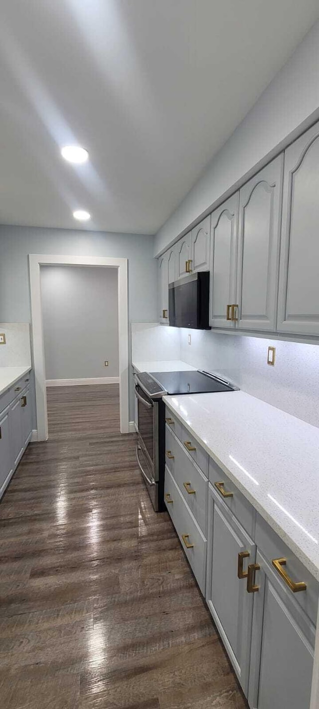 kitchen featuring recessed lighting, baseboards, dark wood-style flooring, appliances with stainless steel finishes, and gray cabinets