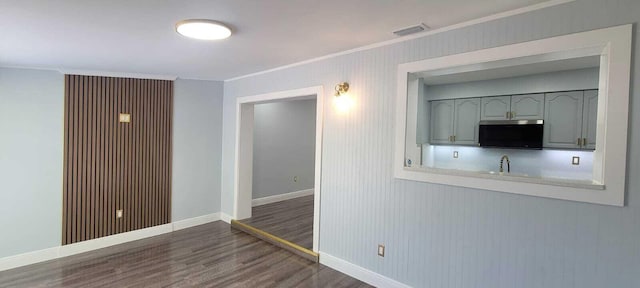 interior space featuring crown molding, visible vents, wood finished floors, and baseboards