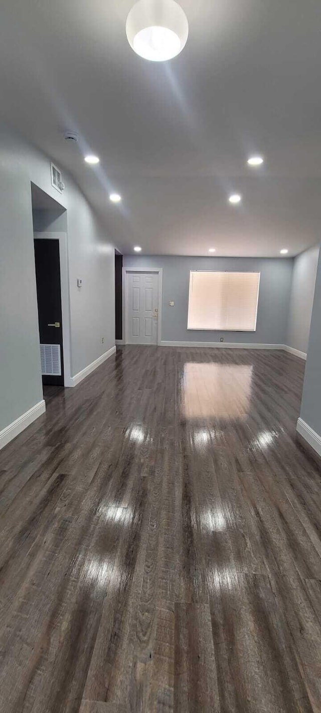 empty room with visible vents, wood finished floors, baseboards, and recessed lighting