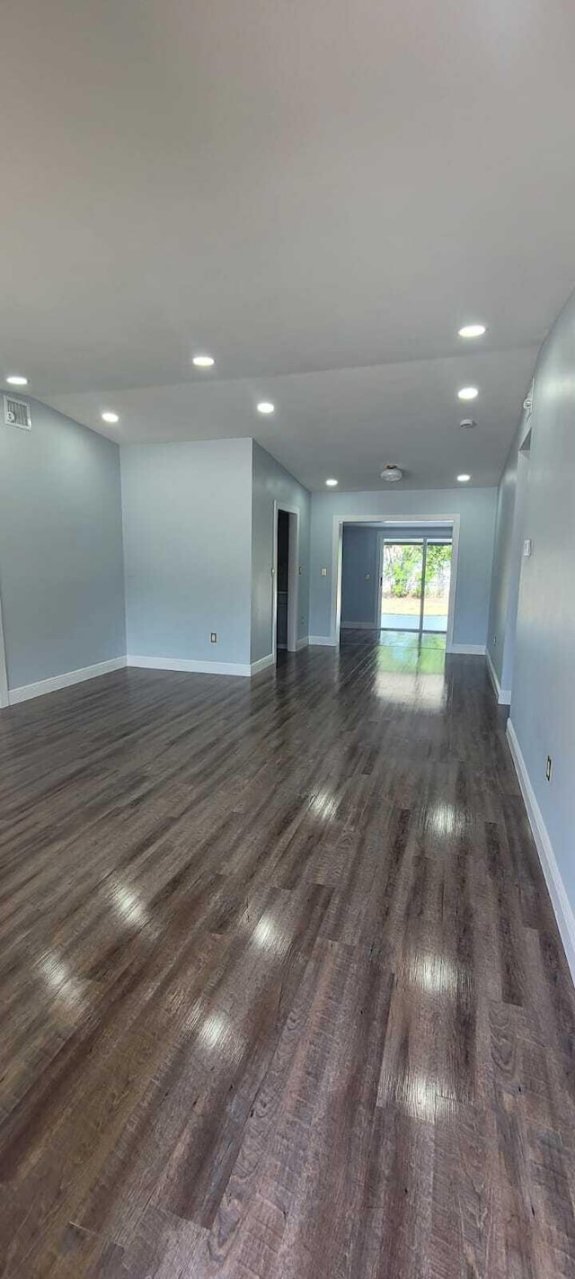 unfurnished room with visible vents, dark wood-style flooring, baseboards, and recessed lighting