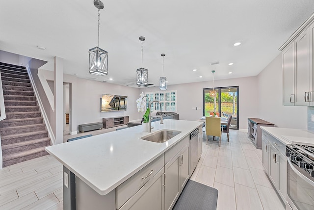 656 SE Villandry Way, Port Saint Lucie, FL 34984 - kitchen with a sink, appliances with stainless steel finishes, light countertops, hanging light fixtures, and gray cabinetry