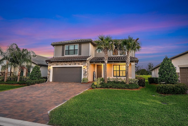 656 SE Villandry Way, Port Saint Lucie, FL 34984 - view of front of house with decorative driveway, stone siding, a garage, a lawn, and a tiled roof