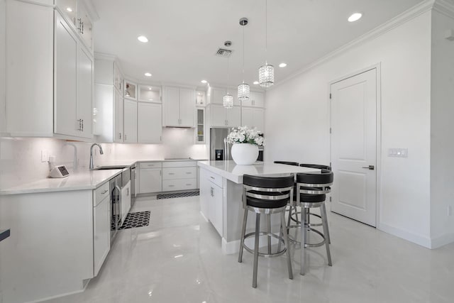 5651 Macoon Way, Westlake, FL 33470 - kitchen with tasteful backsplash, ornamental molding, a kitchen island, a sink, and white cabinetry