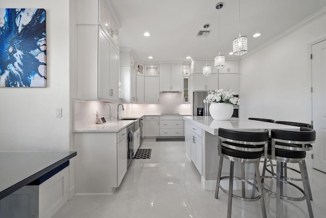 5651 Macoon Way, Westlake, FL 33470 - kitchen featuring decorative backsplash, a breakfast bar area, a sink, white cabinets, and a kitchen island