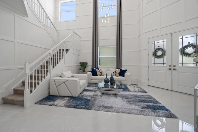 5651 Macoon Way, Westlake, FL 33470 - living area with a decorative wall, stairs, a towering ceiling, and french doors