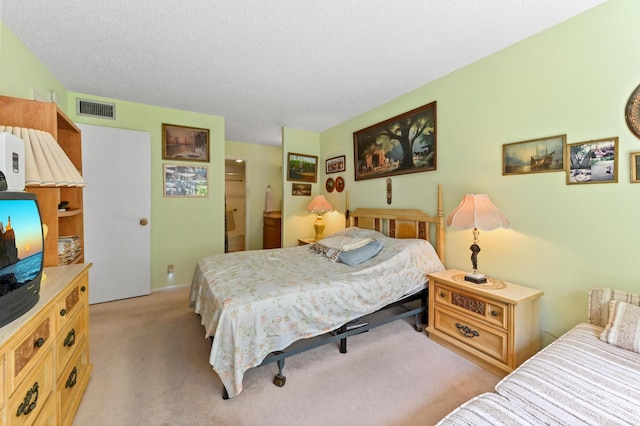 bedroom featuring light colored carpet and a textured ceiling
