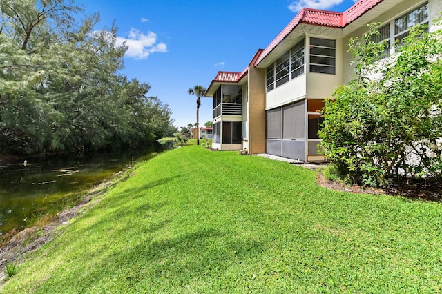 view of green lawn featuring a water view