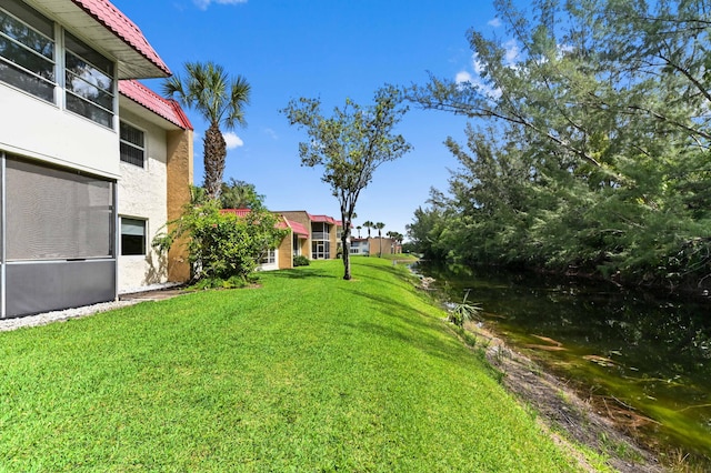 view of green lawn with a water view