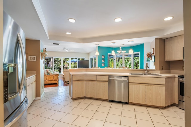 kitchen featuring stainless steel appliances, light brown cabinets, and a sink