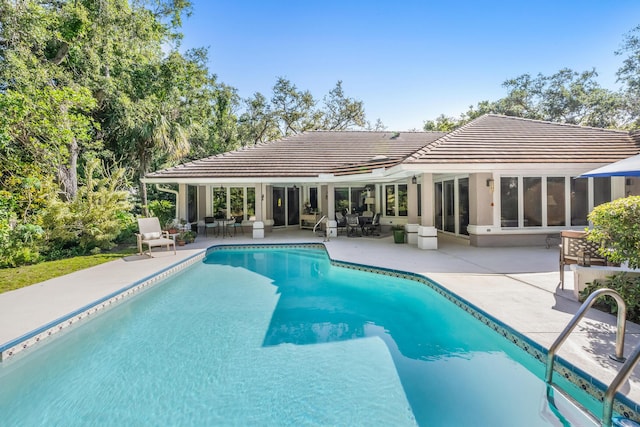 outdoor pool with a patio area and french doors
