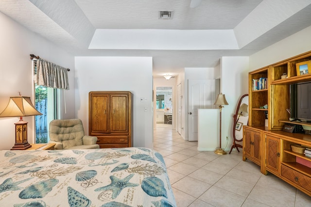 bedroom featuring light tile patterned flooring, multiple windows, visible vents, and a raised ceiling