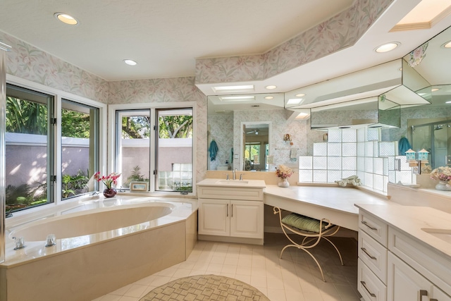 bathroom with recessed lighting, vanity, wallpapered walls, and a bath