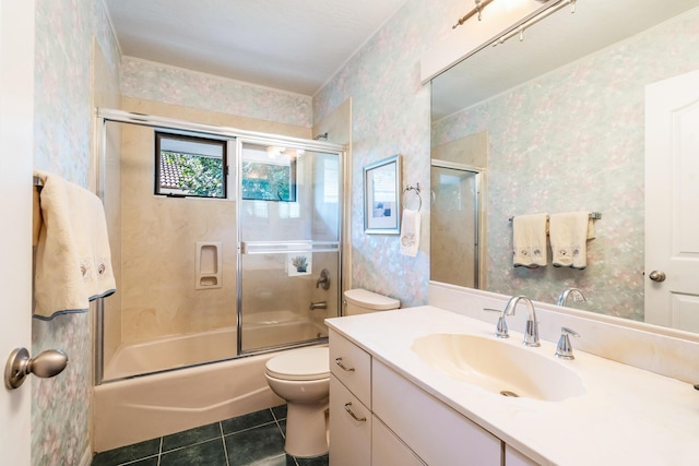 bathroom with toilet, vanity, tile patterned floors, shower / bath combination with glass door, and wallpapered walls