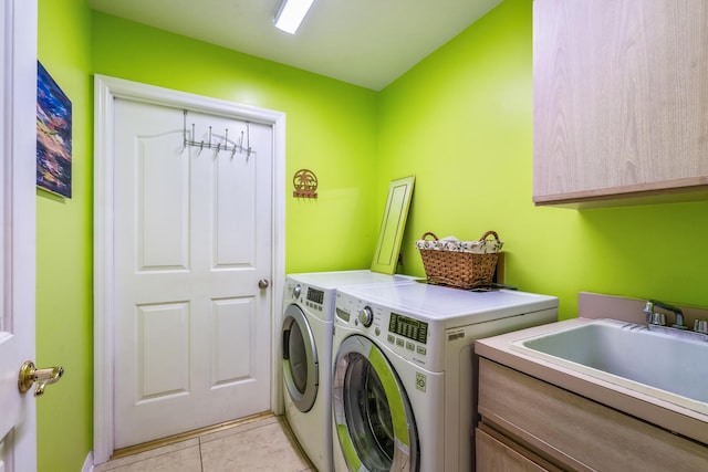 laundry room featuring a sink, light tile patterned flooring, cabinet space, and independent washer and dryer