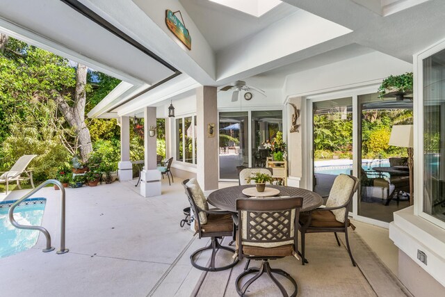 view of patio / terrace with outdoor dining area, a ceiling fan, and an outdoor pool