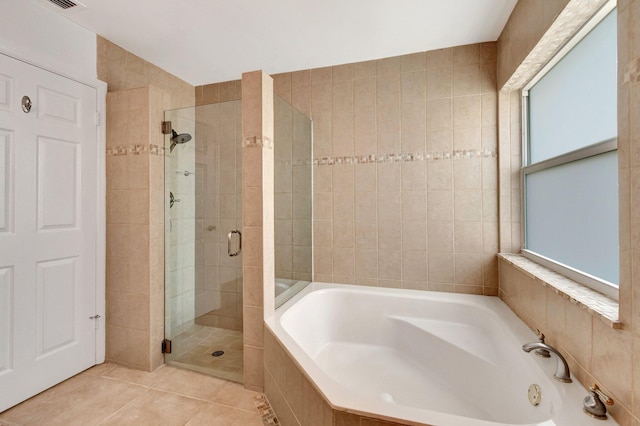 bathroom featuring a shower stall, tile patterned floors, and a bath