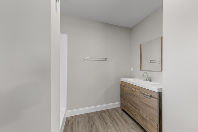 bathroom featuring wood finished floors, vanity, and baseboards