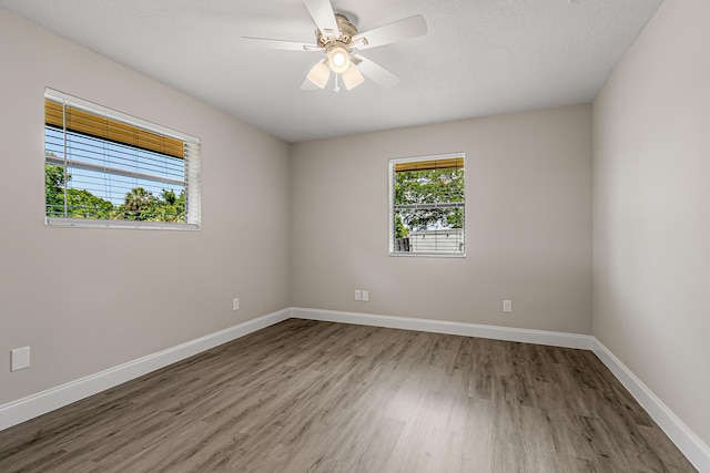 spare room featuring wood finished floors, baseboards, and ceiling fan