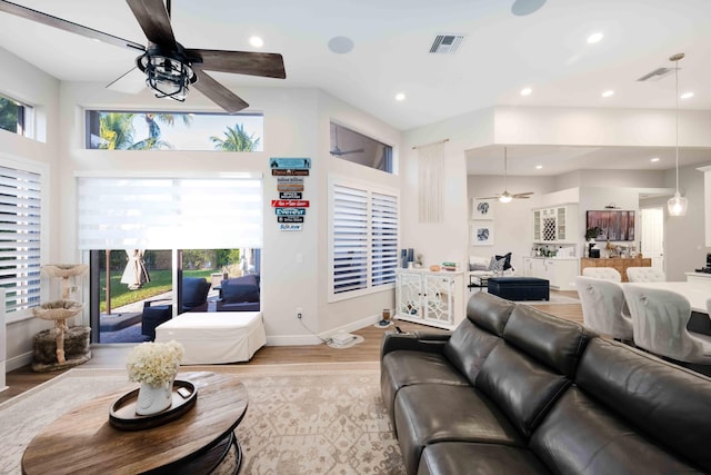 living area featuring ceiling fan, light wood finished floors, healthy amount of natural light, baseboards, and recessed lighting