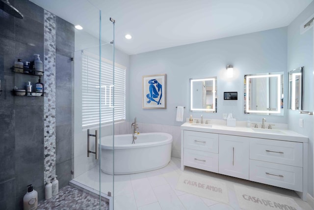 bathroom featuring a tile shower, a freestanding bath, double vanity, recessed lighting, and tile patterned floors