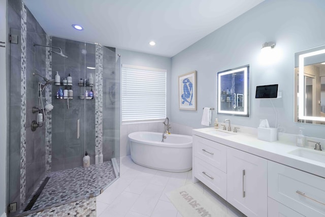 bathroom with a stall shower, a freestanding tub, double vanity, recessed lighting, and tile patterned floors