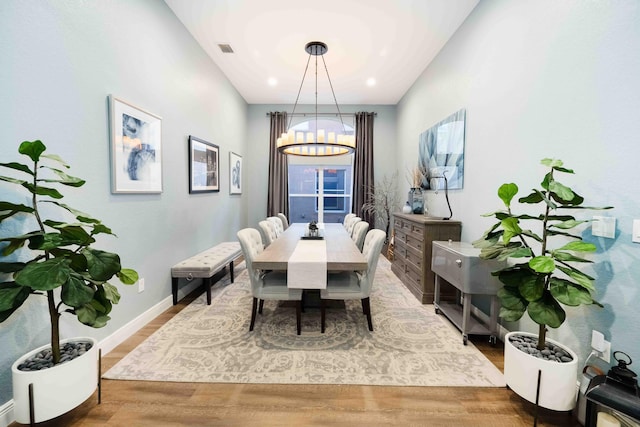 dining area with a chandelier, wood finished floors, baseboards, and recessed lighting