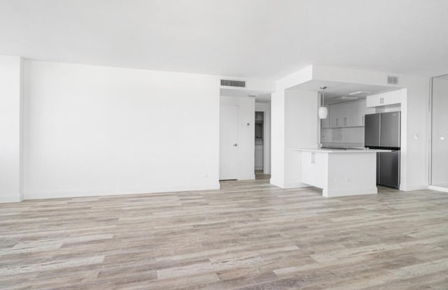 2800 N Flagler Dr Unit 410, West Palm Beach, FL 33407 - unfurnished living room with baseboards, light wood-type flooring, and visible vents