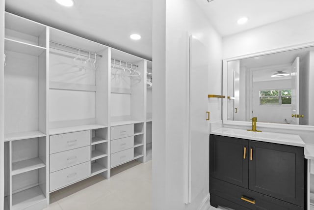 walk in closet with a sink and light tile patterned flooring