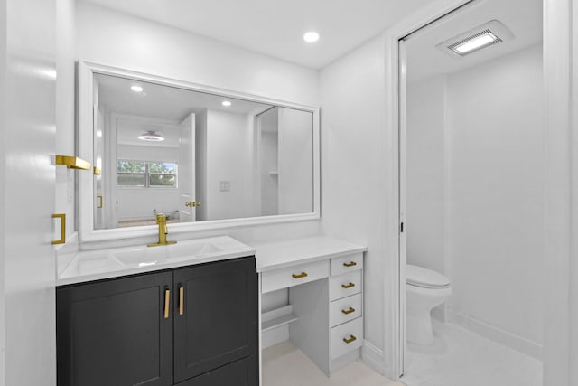 bathroom featuring toilet, vanity, and recessed lighting
