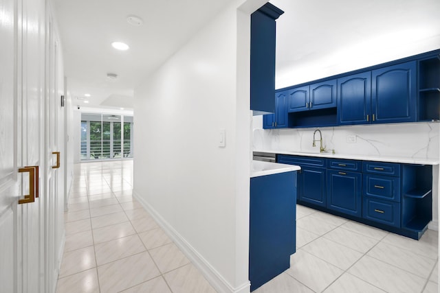 hall featuring a sink, light tile patterned floors, recessed lighting, and baseboards