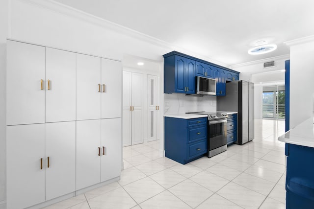 kitchen with appliances with stainless steel finishes, blue cabinetry, ornamental molding, and light tile patterned floors