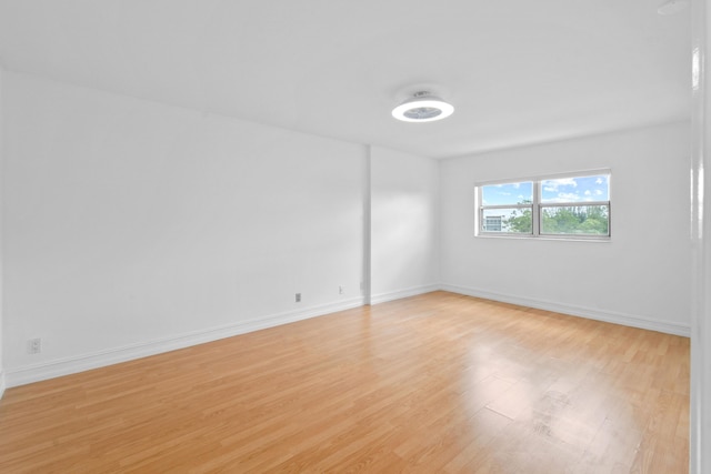 empty room with light wood finished floors and baseboards