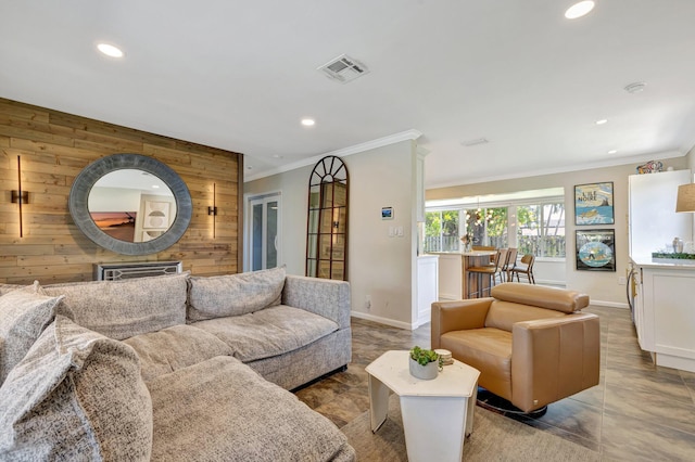 living area featuring crown molding, wood walls, baseboards, visible vents, and recessed lighting