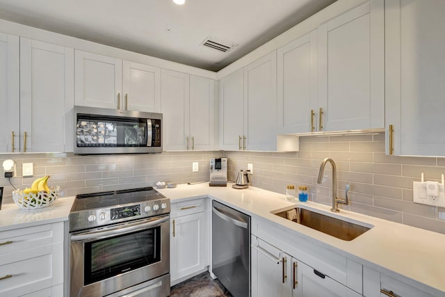 kitchen featuring a sink, stainless steel appliances, white cabinetry, visible vents, and light countertops