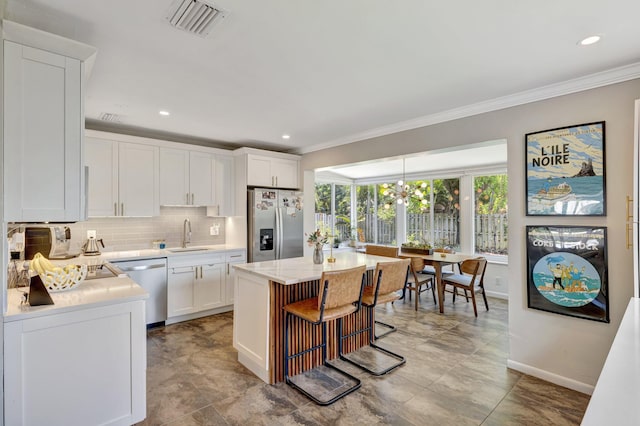 kitchen featuring a sink, ornamental molding, stainless steel appliances, and baseboards
