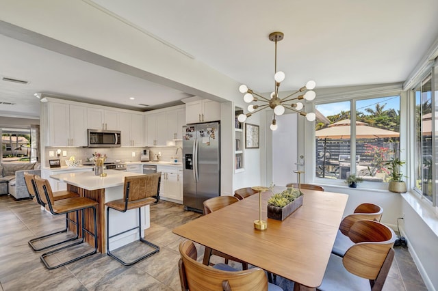 dining room featuring light tile patterned floors, a chandelier, visible vents, and a healthy amount of sunlight