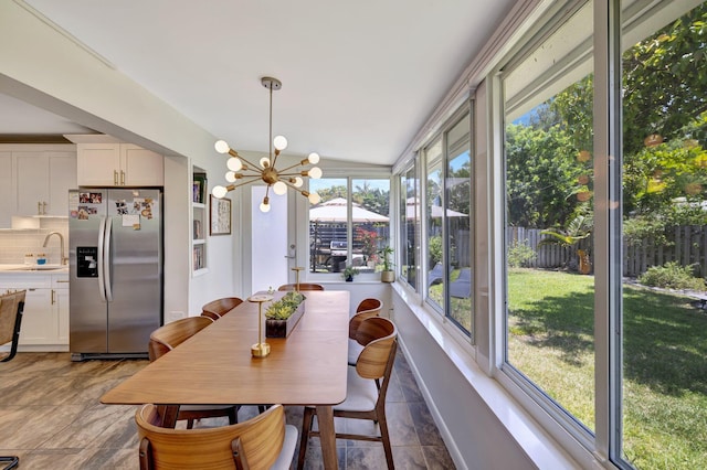 dining room featuring a chandelier and stone finish flooring