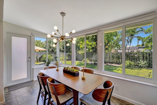dining space featuring a chandelier, baseboards, and tile patterned floors